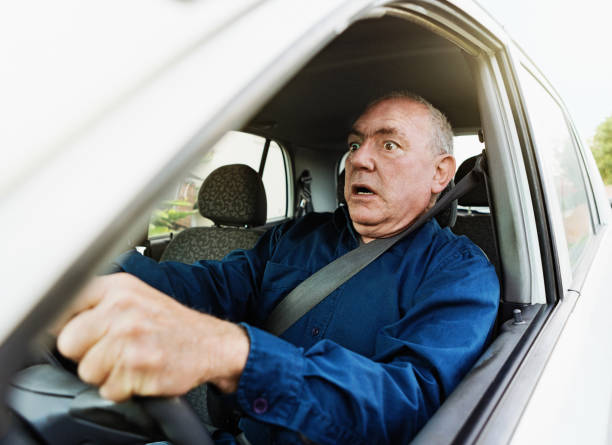 Senior man eyes the road ahead in terror - accident about to happen Senior man looks horrified as he drives. There's danger ahead. gasping stock pictures, royalty-free photos & images