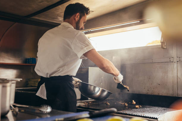 masculino cozinheiro preparando um prato no caminhão de comida - empreendedor dentro de seu caminhão - fotografias e filmes do acervo