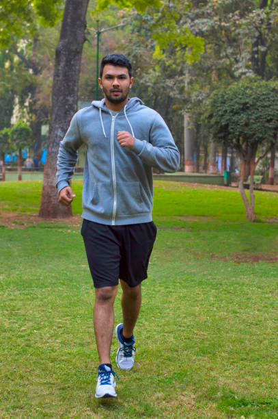 Young guy jogging in a park stock photo