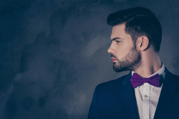 istock Profile side view portrait with copy space empty place of cool stunning man with bow in blue suit isolated on dark grey background 979047366