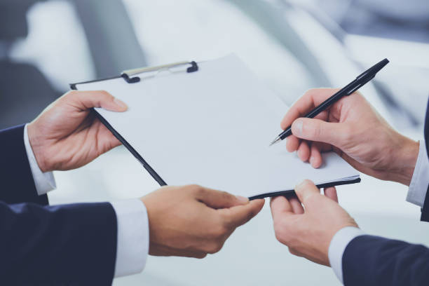 Close up two men signing contract at car showroom Close up two men signing contract at car showroom. Business concept general manager stock pictures, royalty-free photos & images