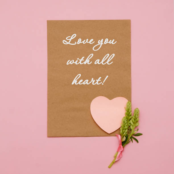 istock Composition with flowers and notebook on pink background. Hand writing with love confession. Flat lay. 979061434