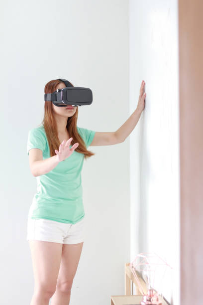 istock Young woman wearing virtual reality glasses at home. 979071948