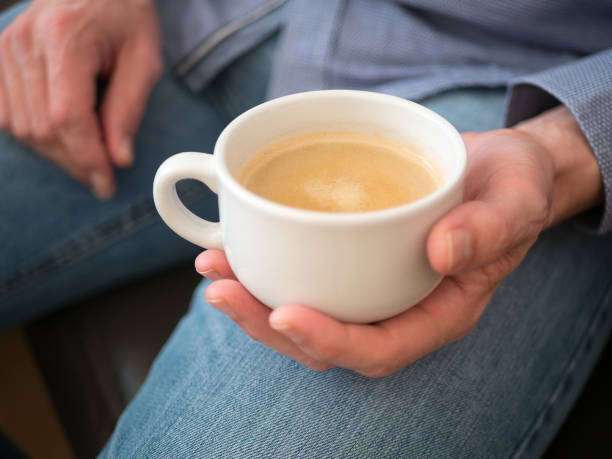 istock Man holds coffee cup in his hand 979085988
