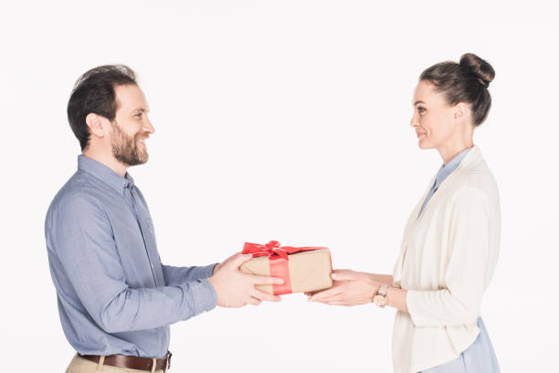 istock side view of smiling man presenting wrapped gift to wife isolated on white 979087330