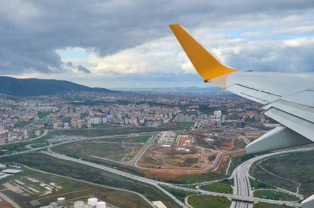 飛行機窓の地球からの眺めはグランド川と雲の旅行観光イスタンブール トルコです。雲の上を飛んでいる飛行機の翼は地面嵐は曇り空です。 - mountain range earth sky airplane ストックフォトと画像