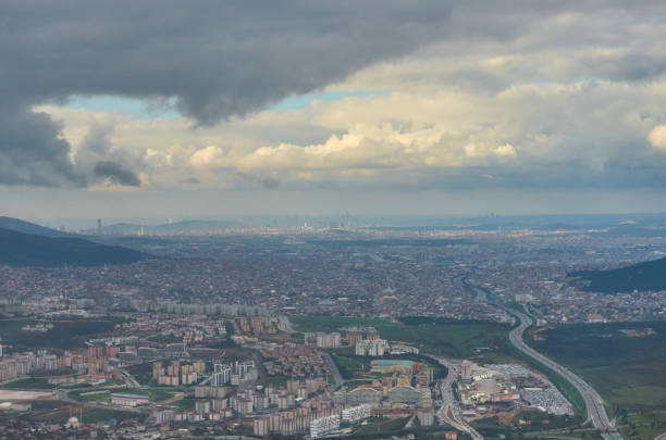 飛行機窓の地球からの眺めはグランド川と雲の旅行観光イスタンブール トルコです。雲の上を飛んでいる飛行機の翼は地面嵐は曇り空です。 - mountain range earth sky airplane ストックフォトと画像