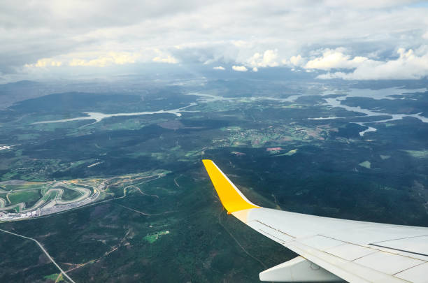 飛行機窓の地球からの眺めはグランド川と雲の旅行観光イスタンブール トルコです。雲の上を飛んでいる飛行機の翼は地面嵐は曇り空です。 - mountain range earth sky airplane ストックフォトと画像