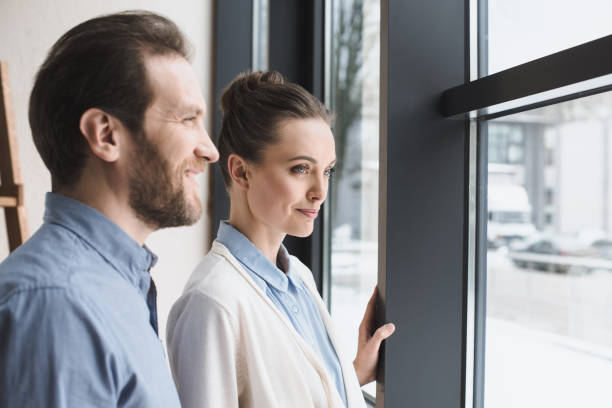 istock side view of smiling couple looking out window together 979091630