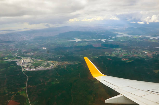飛行機窓の地球からの眺めはグランド川と雲の旅行観光イスタンブール トルコです。雲の上を飛んでいる飛行機の翼は地面嵐は曇り空です。 - mountain range earth sky airplane ストックフォトと画像