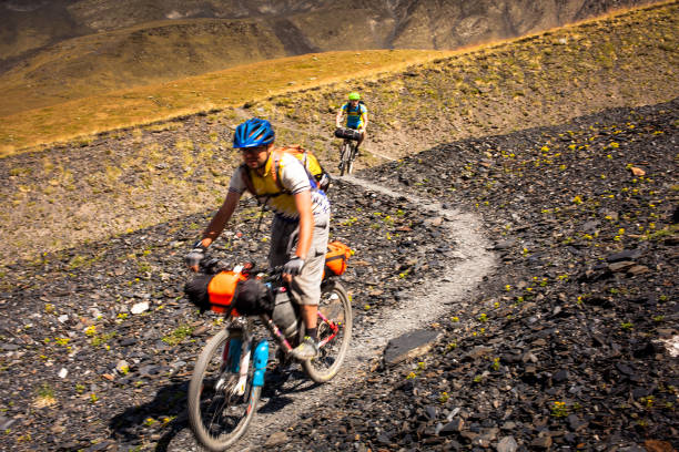 mountain bikers are travelling in the highlands of tusheti region, georgia - tusheti imagens e fotografias de stock