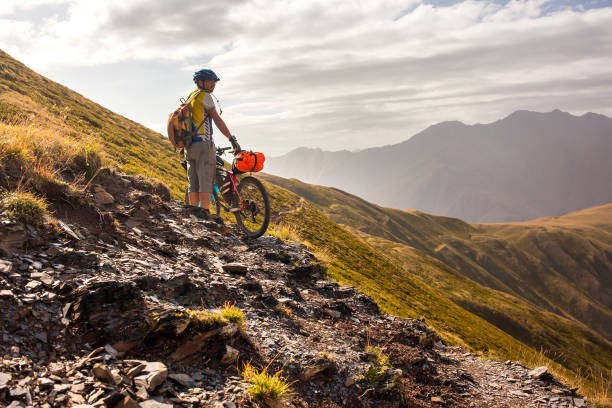 istock Biker pushes his bicycle up in high Caucasus mountains 979096940