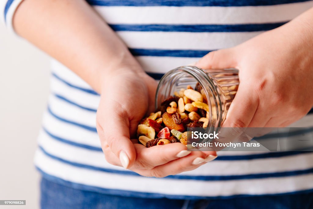 Nuts and dried fruits in hands. Cooking Hands holding a jar of nuts and dried fruits. Healthy breakfast. Sweet and healthy food, snack Snack Stock Photo