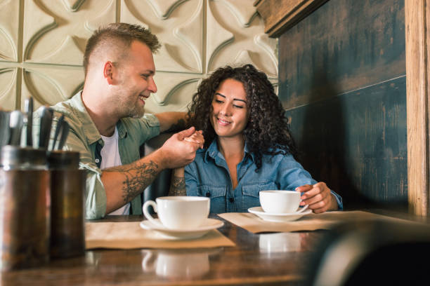 istock Happy young couple is drinking coffee and smiling while sitting at the cafe 979100614