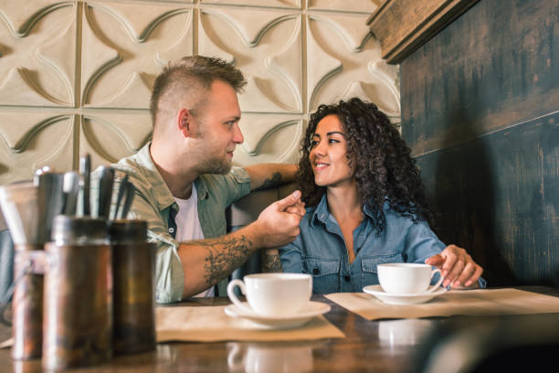 istock Happy young couple is drinking coffee and smiling while sitting at the cafe 979102856