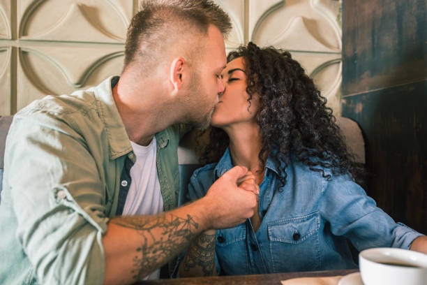 istock Happy young couple is drinking coffee and smiling while sitting at the cafe 979103536