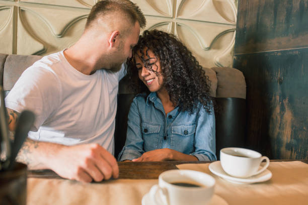 istock Happy young couple is drinking coffee and smiling while sitting at the cafe 979105370