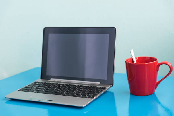 istock Close-Up Of Laptop On Table Against Blue Background 979108786