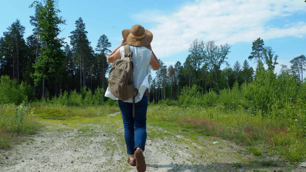 istock Woman is walking on the forest road 979112586