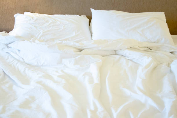 istock Messy white bed and pillow, in the morning 979122998