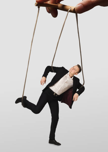 istock Hand manipulating a businessman puppet on white background 979123210