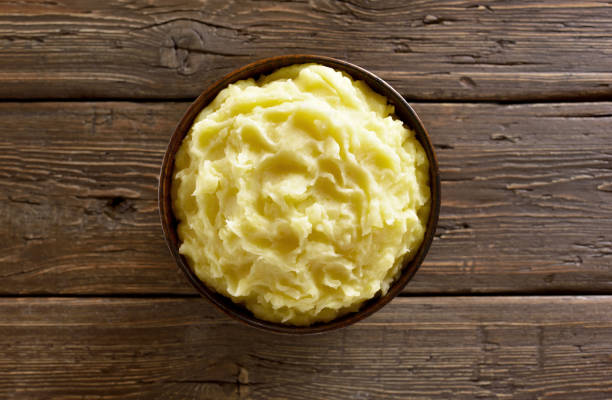 Mashed potatoes in bowl Mashed potatoes in bowl on wooden background. Top view, flat lay mashed potatoes stock pictures, royalty-free photos & images