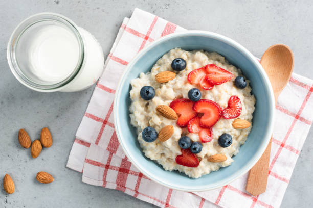 porridge di farina d'avena con bacche fresche e noci, vista dall'alto - avena cereali da colazione foto e immagini stock