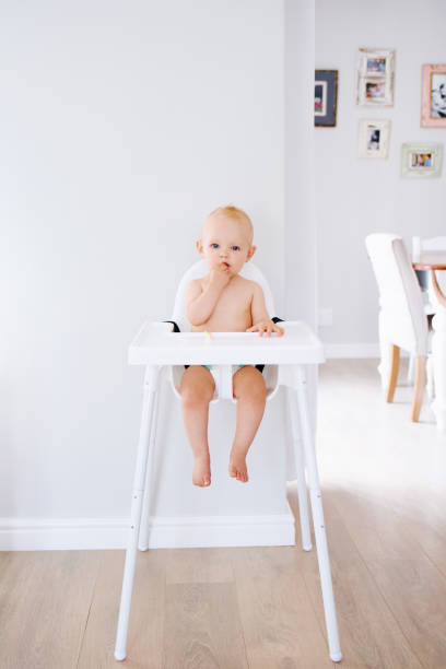 A messy baby eating in a high chair.
