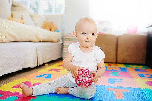 Shot of an adorable baby girl playing with a toy at home