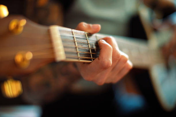 istock Young woman playing guitar close up 979162182
