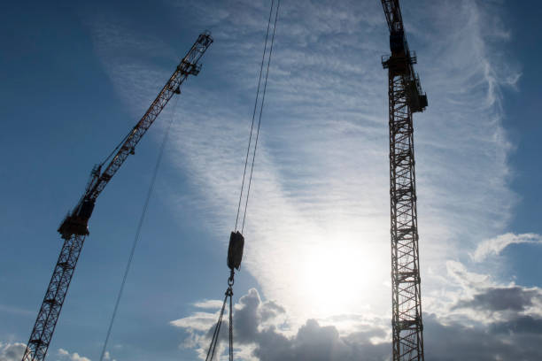 istock Silhouette of high construction cranes 979164886