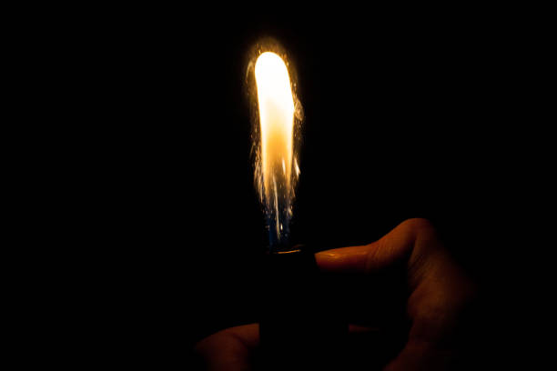 istock Close up view of real sparking light from lighter in dark black background 979167160
