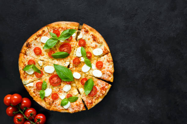 istock Hot italian pizza with tomatoes, basil and mozzarella on black stone background 979167688