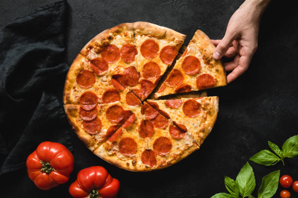 rebanada de picking de mano humana de pizza de pepperoni - pizza de chorizo fotos fotografías e imágenes de stock
