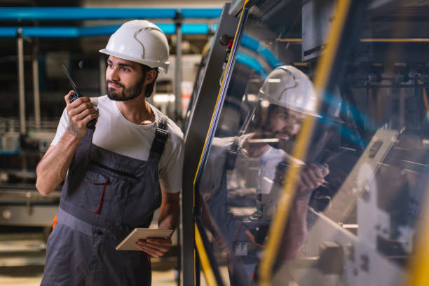 istock Factory worker controlling production and talking with colleague on walkie-talkie 979176356