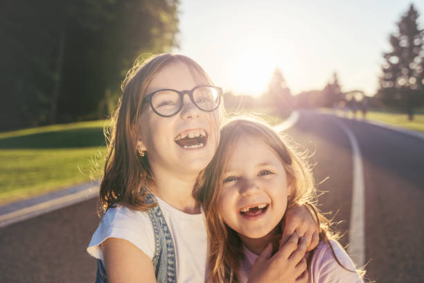 istock Two joyful girls hugging and smiling against the sunset. 979180268