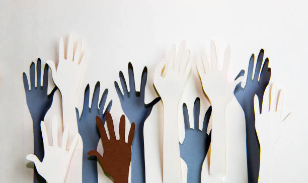istock Humans hands raised up celebrating togetherness, teamwork and support. Paper made background 979183010