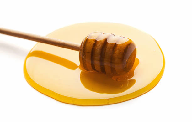 istock Honey and wooden dipper isolated on white 979194946