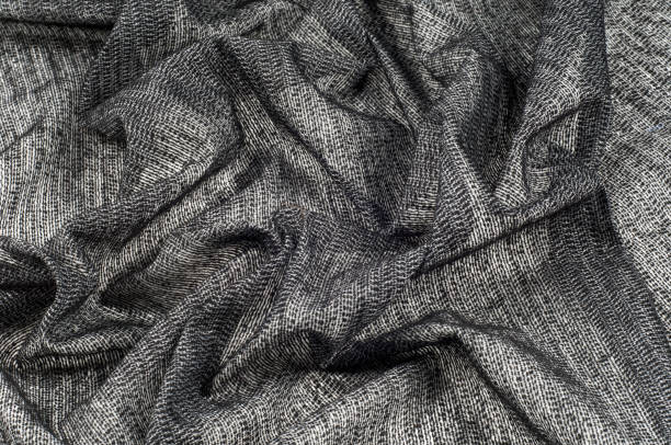 istock fabric gray black with white inserts metallic gold Thin white yarns are drawn on a black background, and thicker white yarns, twisted with a small amount of gold, create an almost spattered appearance 979195550
