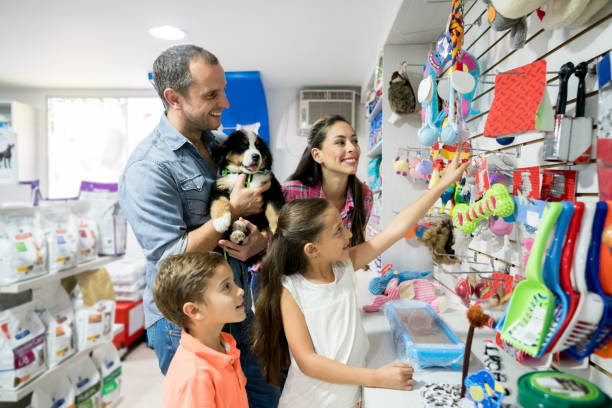 Happy family shopping at a pet shop Happy Latin American family shopping at a pet shop with a new puppyâ animal lifestyle concepts pet shop photos stock pictures, royalty-free photos & images