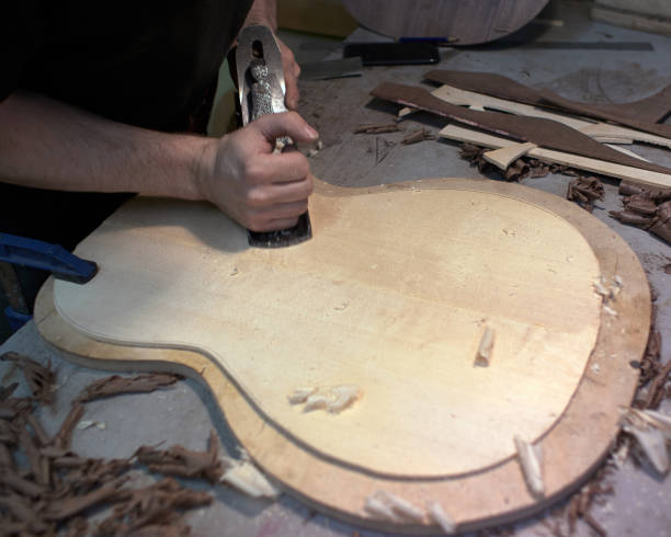 istock The guitar master scribbles Soundboard of the future classical guitar with a plane. 979198788