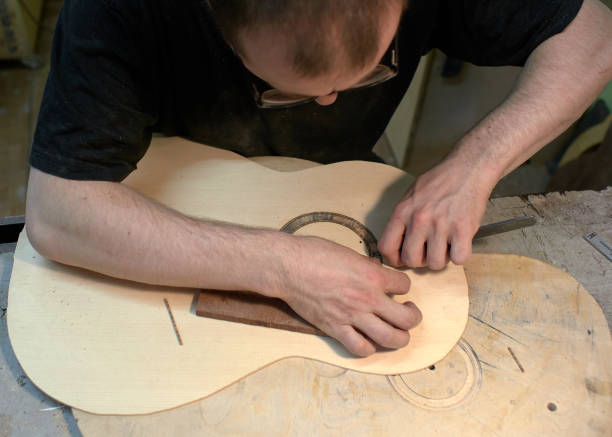 istock The guitar master installs  rosette in a classical guitar. 979199922