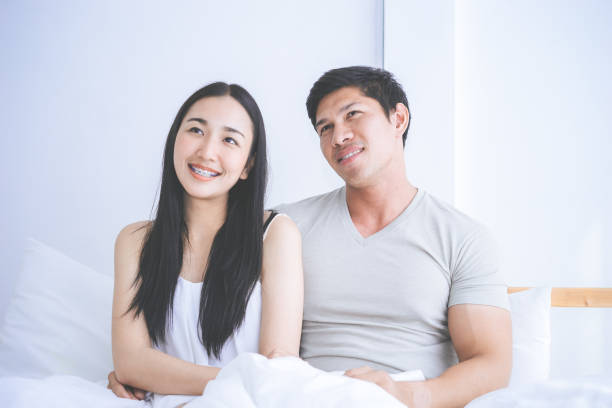 istock Happy Asian couple looking up on bed 979200718