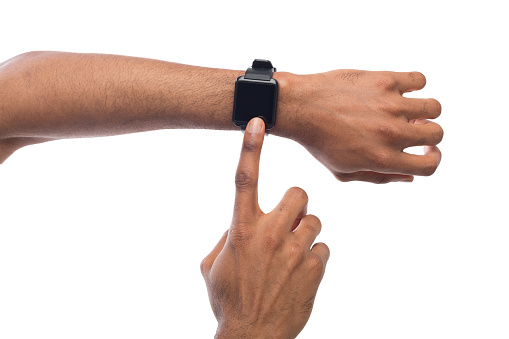 Smartwatch at black male hand, white background cutout. Modern digital gadget with empty display, copy space