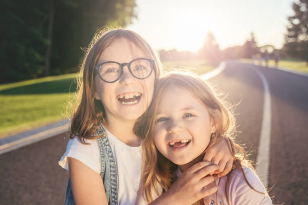istock Two joyfull girls hugging and smiling against the sunset. 979204408