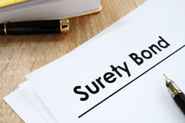 Photo of Surety bond form and pen on a table.