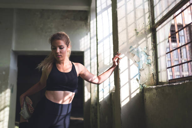 istock Handsome sportswoman stretching legs 979206848