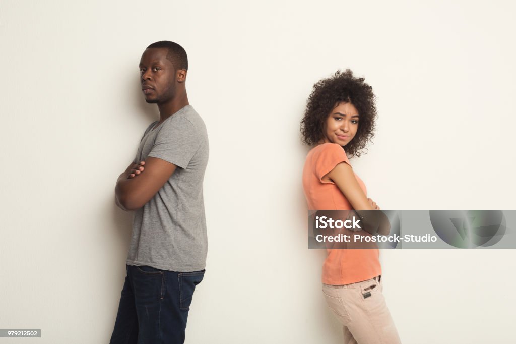 Break up, upset couple back to back after quarrel Break up or divorce. Upset young african-american couple standing back to back after quarrel, isolated white background, family misunderstanding concept, copy space Back To Back Stock Photo