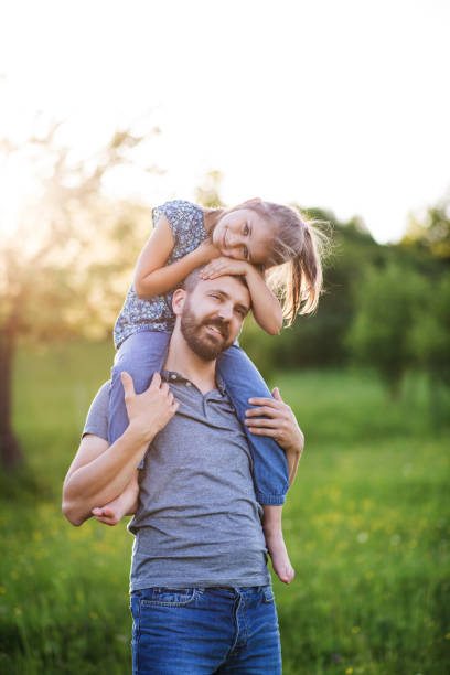 istock Father giving small daughter a piggyback ride in spring nature. 979212570