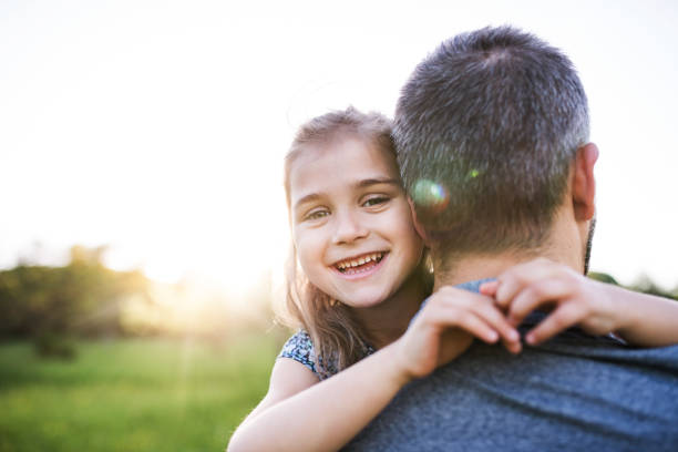 istock Father holding a small daughter in spring nature at sunset. 979213804